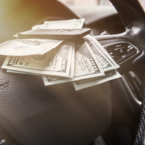 100 dollar bills with car key inside of car