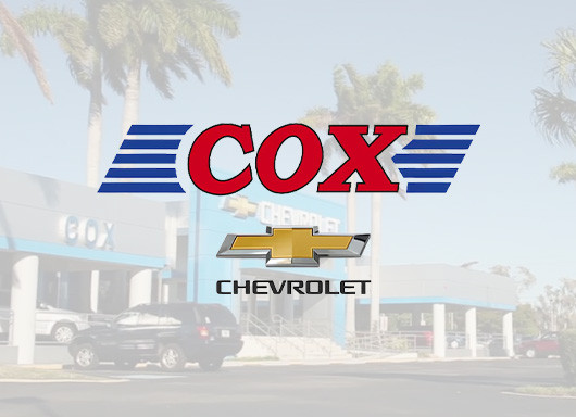 Cox Chevrolet logo with dealership in background