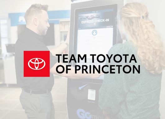 Team Toyota of Princeton logo with a man and woman using the Service Express kiosk in the background