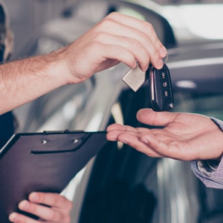 Closeup of mechanic handing keys to businessman