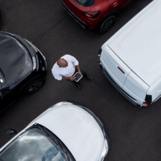Fleet manager inspecting fleet vehicles in parking lot