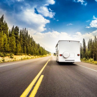 RV driving down a tree-lined road