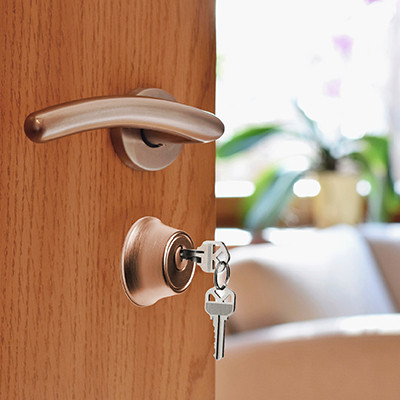 Image of keys in open apartment door.